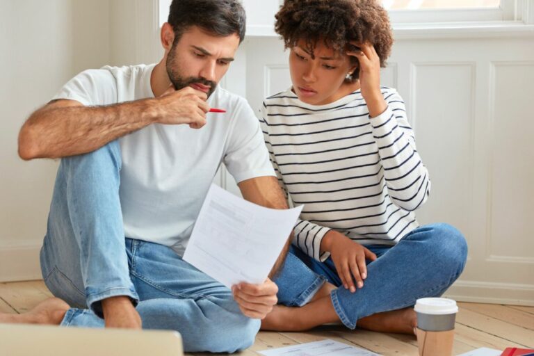 Un jeune ocuple regarde leur contrat d'assurance habitation après avoir emménagé